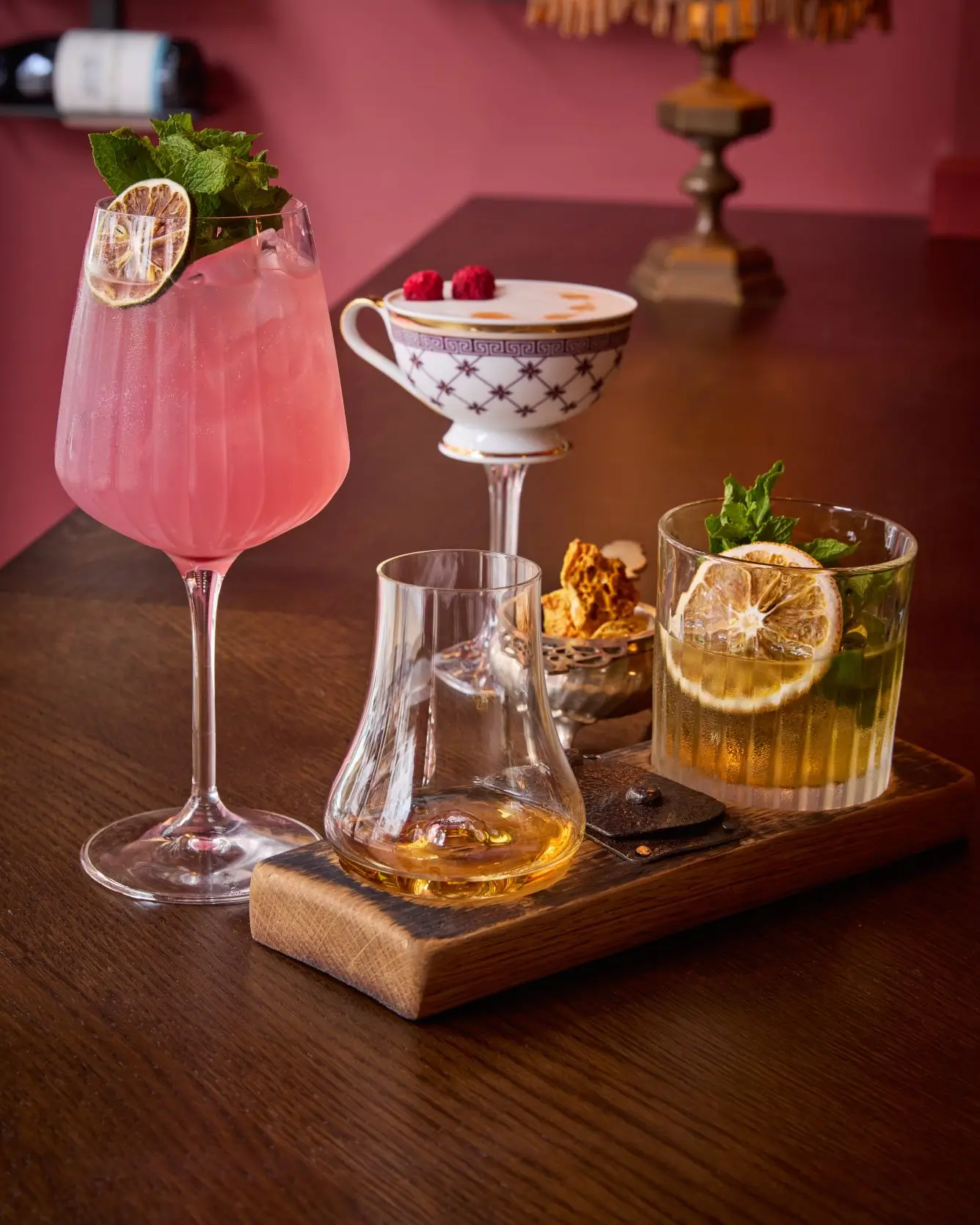 A vibrant selection of craft cocktails from Fitzers Bar, including a pink gin drink, a whiskey cocktail, a raspberry foam cocktail, and a glass of neat whiskey.